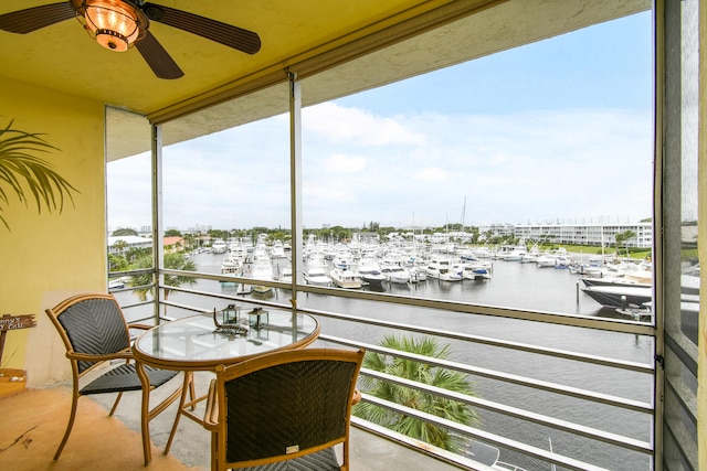 balcony featuring a water view and ceiling fan