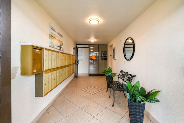 interior space with a textured ceiling, tile patterned flooring, and mail boxes