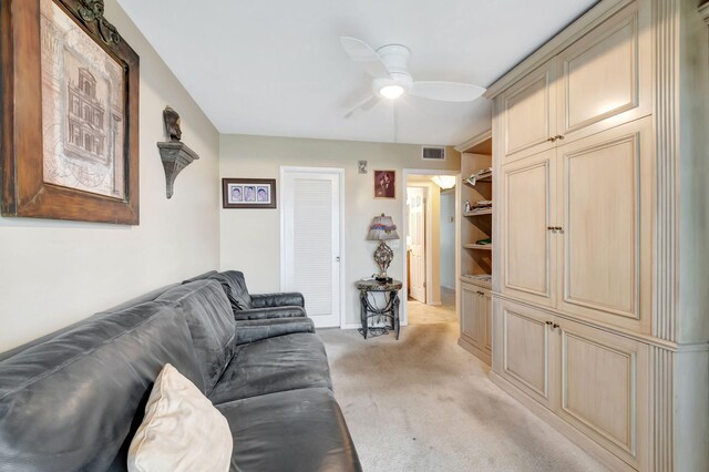 carpeted living room with ceiling fan