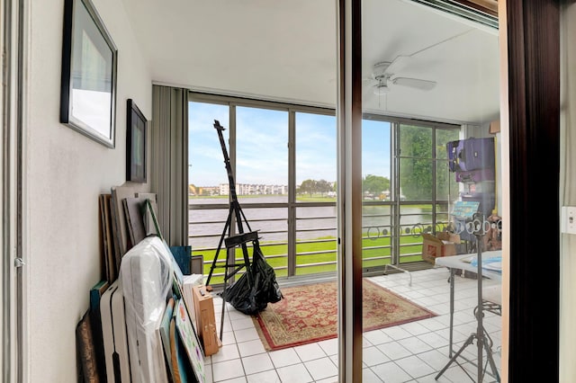 sunroom / solarium featuring a water view, ceiling fan, and a healthy amount of sunlight