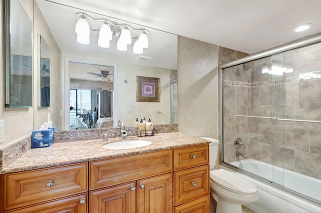 full bathroom with vanity, shower / bath combination with glass door, toilet, and ceiling fan