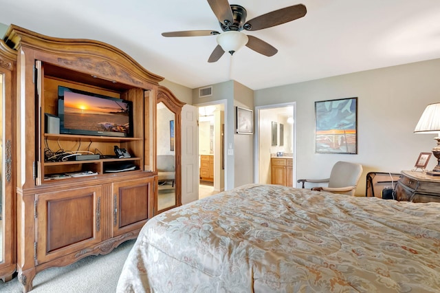 carpeted bedroom with ensuite bath and ceiling fan