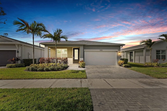 single story home with a lawn and a garage