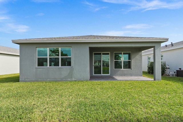 rear view of house featuring a patio and a lawn