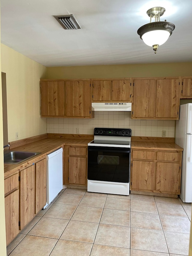 kitchen featuring light tile patterned floors, sink, white appliances, and tasteful backsplash