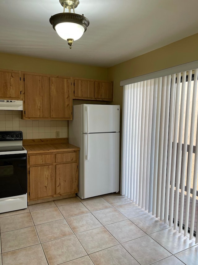 kitchen with decorative backsplash, light tile patterned floors, and white appliances