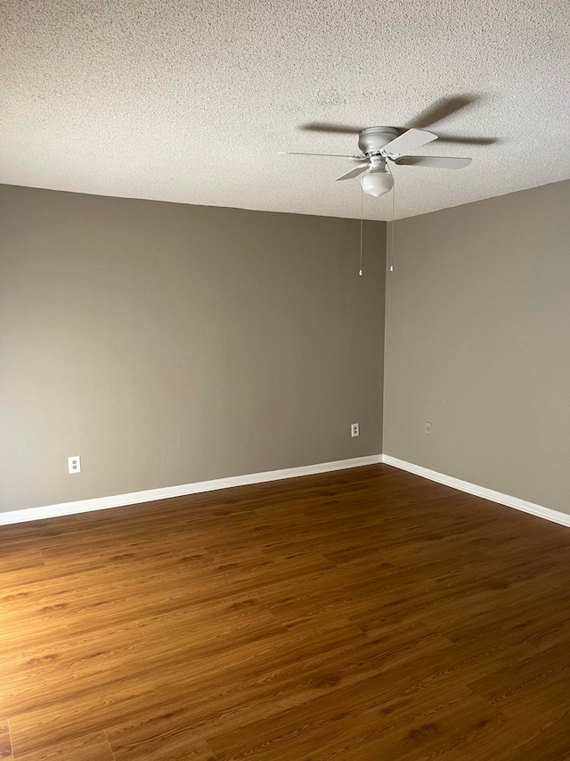 spare room featuring a textured ceiling, dark hardwood / wood-style floors, and ceiling fan