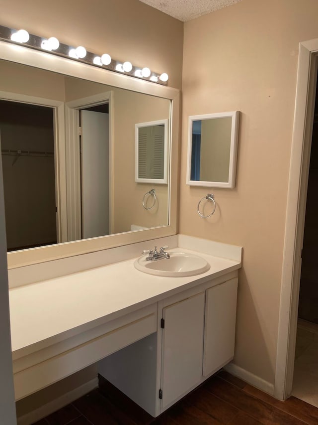 bathroom with vanity, a textured ceiling, and hardwood / wood-style flooring