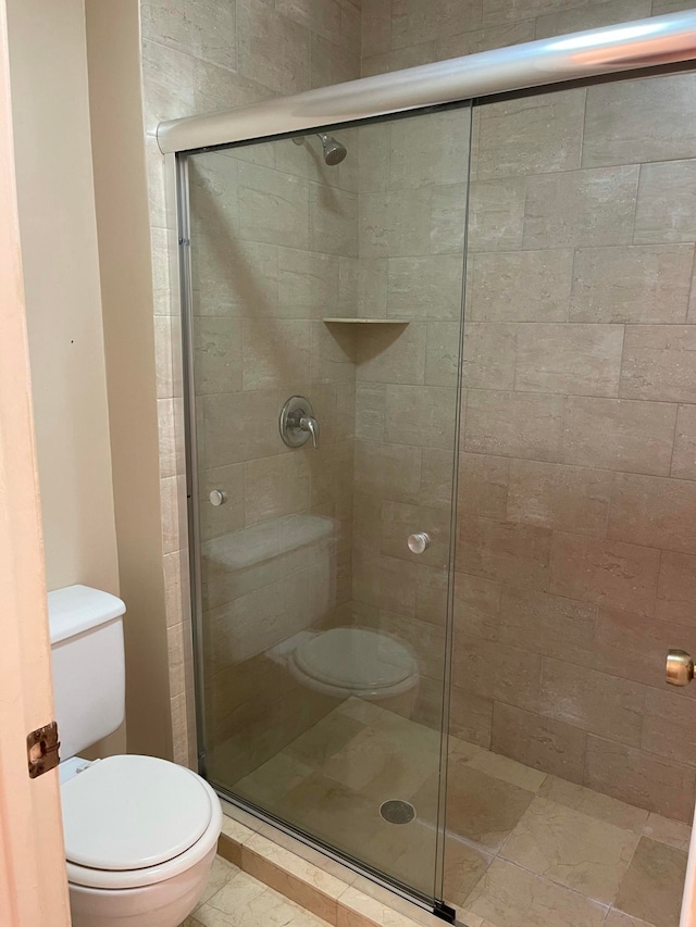 bathroom with toilet and an enclosed shower