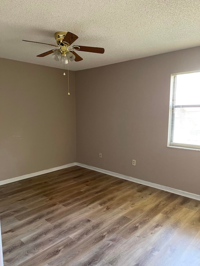 spare room featuring a textured ceiling, wood-type flooring, and ceiling fan