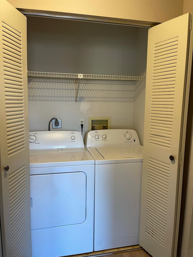 washroom featuring hardwood / wood-style floors and washer and clothes dryer