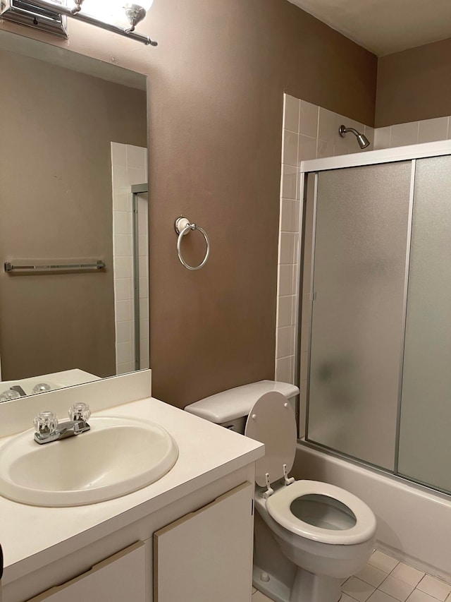 full bathroom with toilet, bath / shower combo with glass door, vanity, and tile patterned flooring