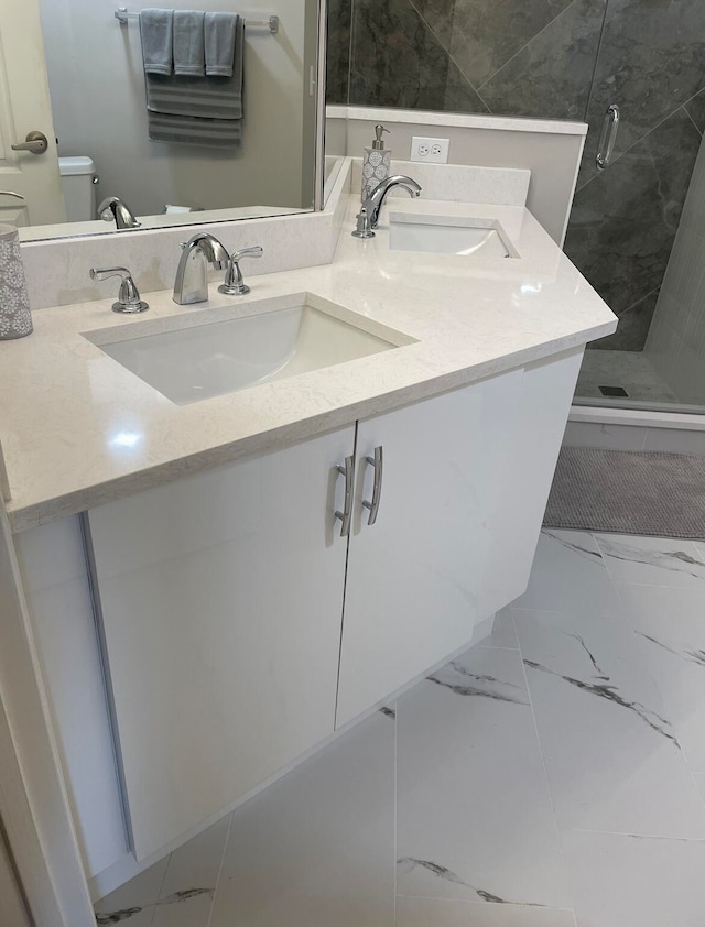 bathroom with a shower with door, vanity, and toilet