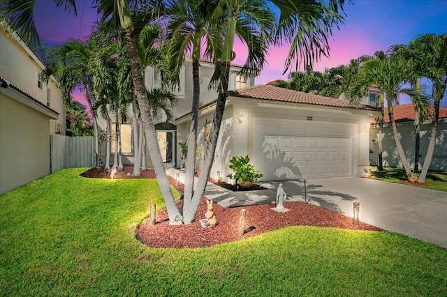 mediterranean / spanish-style house with a garage and a lawn