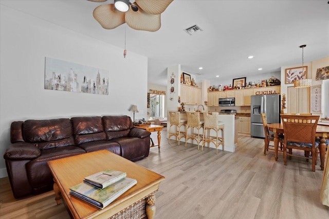 living room featuring ceiling fan and light wood-type flooring