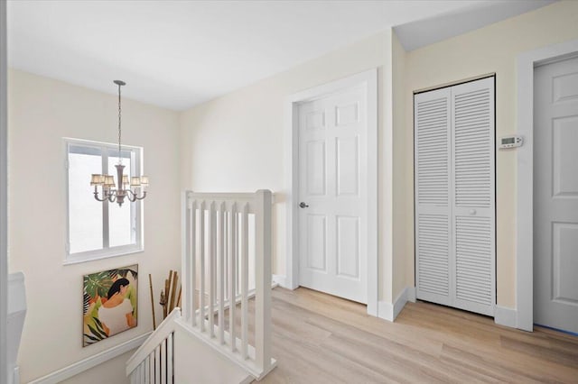 hallway featuring a notable chandelier and light hardwood / wood-style flooring