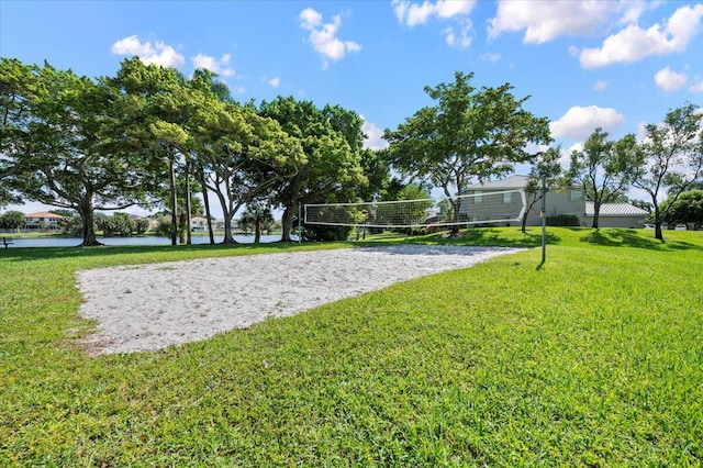 view of property's community with a water view, a lawn, and volleyball court