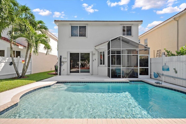 rear view of house featuring a patio, a sunroom, and a fenced in pool