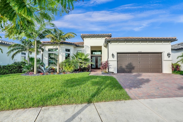 mediterranean / spanish home featuring a garage and a front lawn