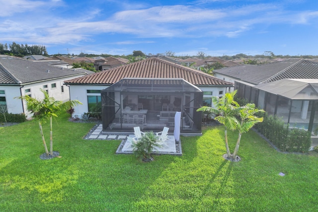 rear view of house with a patio area, a lanai, a yard, and a pool