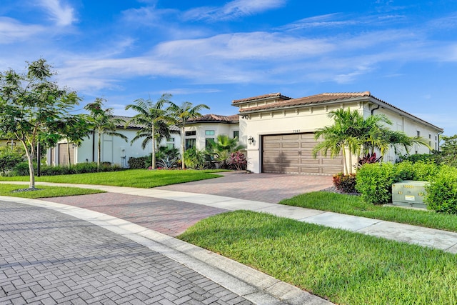 mediterranean / spanish home with a front yard and a garage