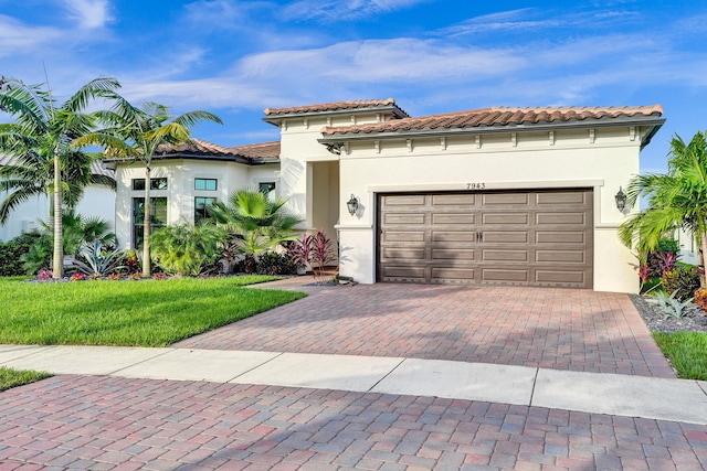 mediterranean / spanish home featuring a front yard and a garage