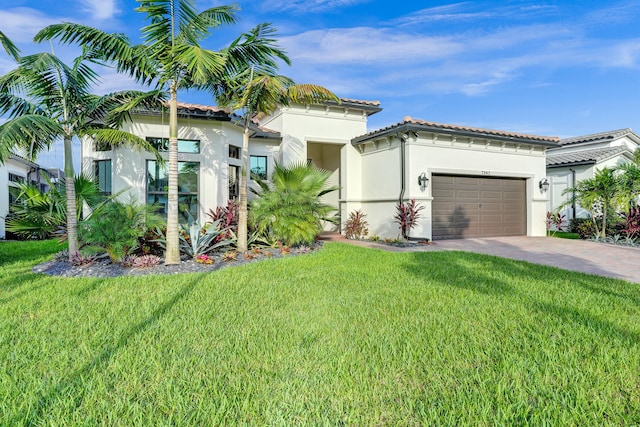 mediterranean / spanish house with a garage and a front lawn