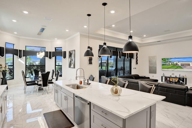 kitchen featuring a kitchen island with sink, a wealth of natural light, sink, pendant lighting, and light stone counters