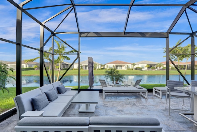 view of patio / terrace with an outdoor living space, a water view, and glass enclosure