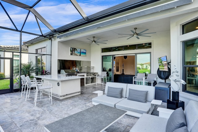 view of patio / terrace featuring area for grilling, glass enclosure, ceiling fan, an outdoor bar, and an outdoor living space