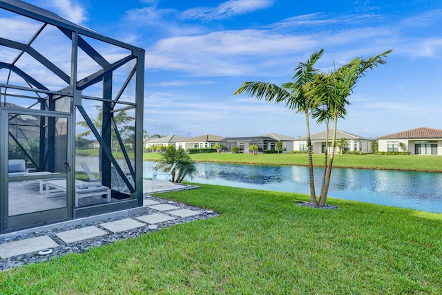 view of yard with a water view and glass enclosure