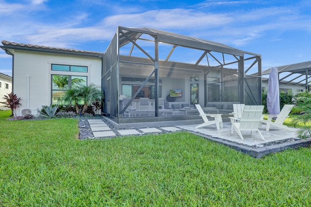 back of property with a yard, a patio area, and glass enclosure