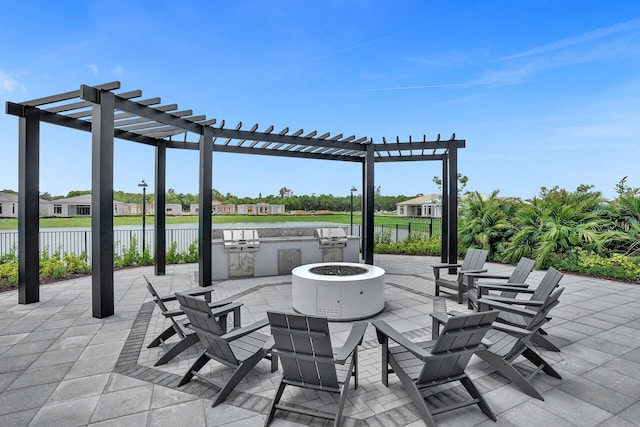 view of patio / terrace with area for grilling, a water view, a fire pit, and a pergola