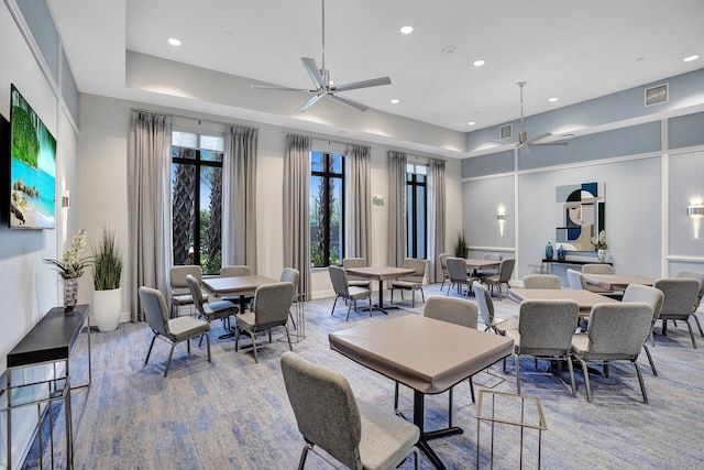 carpeted dining space with ceiling fan