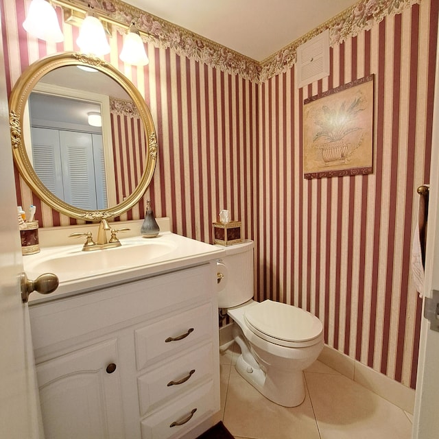 bathroom with tile patterned flooring, vanity, and toilet