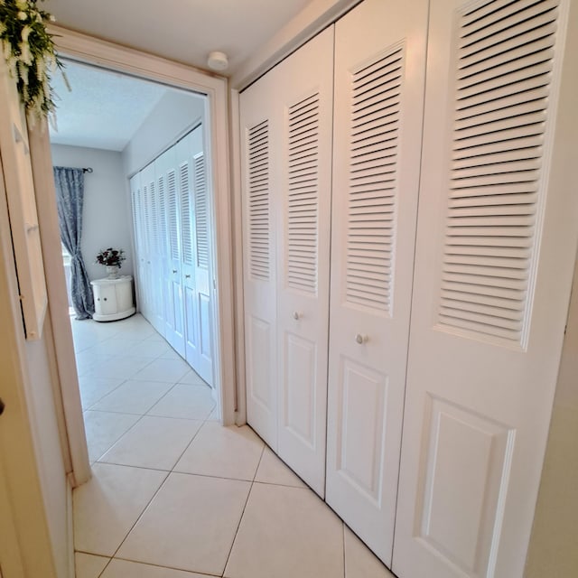 hall with light tile patterned floors