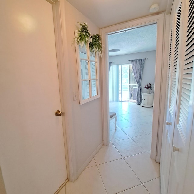 hallway featuring a textured ceiling and light tile patterned floors