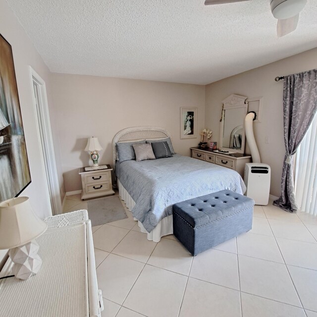 tiled bedroom with a textured ceiling and ceiling fan