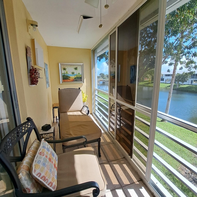 sunroom featuring a water view