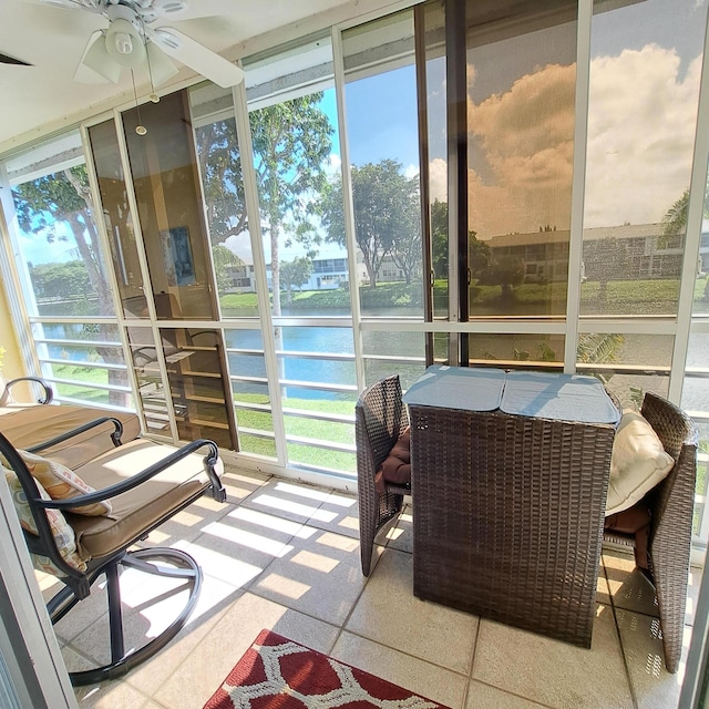 sunroom featuring a water view, ceiling fan, and plenty of natural light