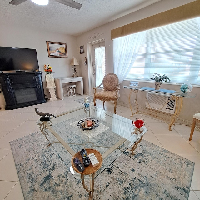 living room featuring ceiling fan, tile patterned floors, and a textured ceiling