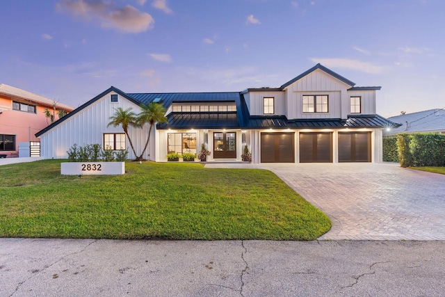 modern farmhouse style home featuring a yard and a garage