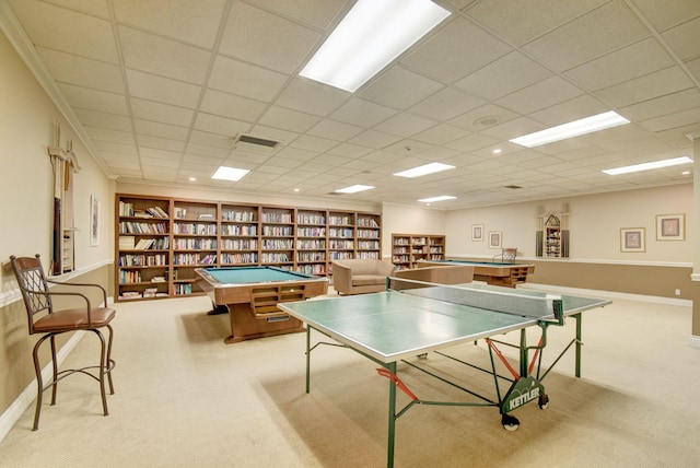 game room featuring built in shelves, a paneled ceiling, and light carpet