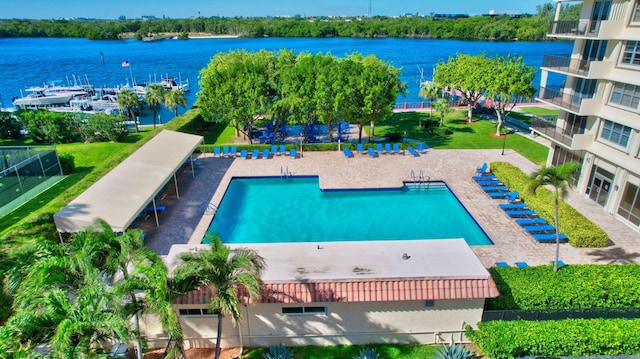 view of swimming pool featuring a patio and a water view