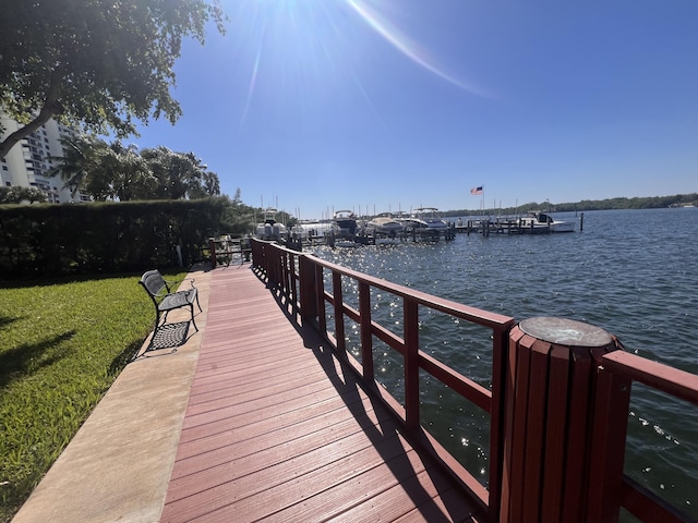 dock area featuring a lawn and a water view