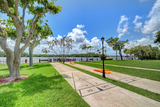 surrounding community with a yard and a water view