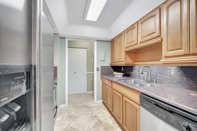 kitchen with sink, decorative backsplash, a tray ceiling, and appliances with stainless steel finishes