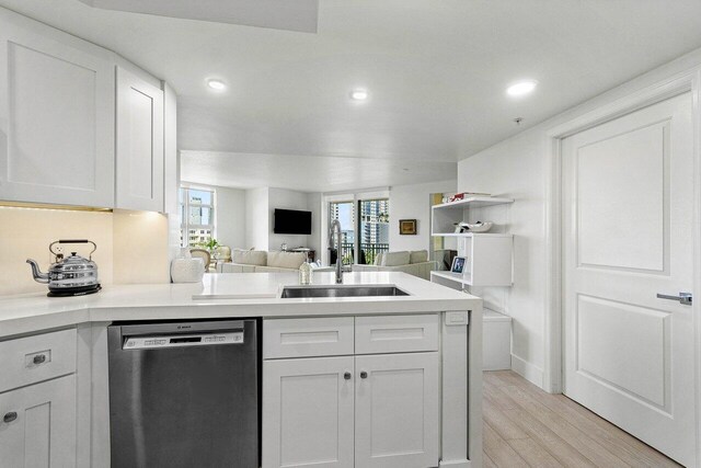 kitchen with sink, a healthy amount of sunlight, white cabinetry, and dishwasher