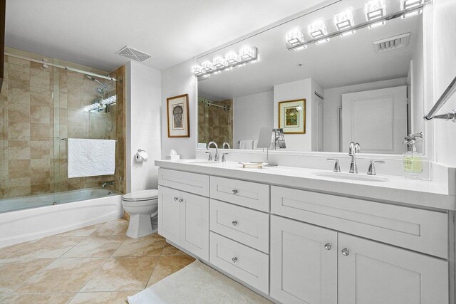 full bathroom with vanity, toilet, tile patterned flooring, and bath / shower combo with glass door