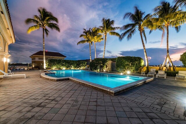 pool at dusk with a patio